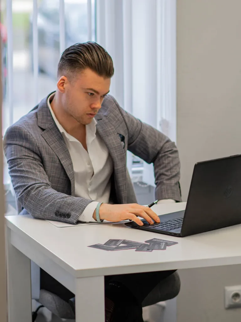 agent nieruchomości pracuje na laptopie w biurze i przygotowuje sprzedaż nieruchomości